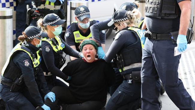 Police try to restrain the woman. Picture: Alex Coppel