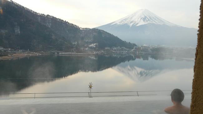 A bather watches the sun set on snow-capped Mt Fuji, Japan. Picture: Toursgallery