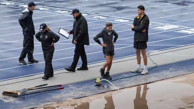 The rain kept coming at the NSW Junior Athletics Championships. Here officials pump out rain water from the waterlogged long jump pit.