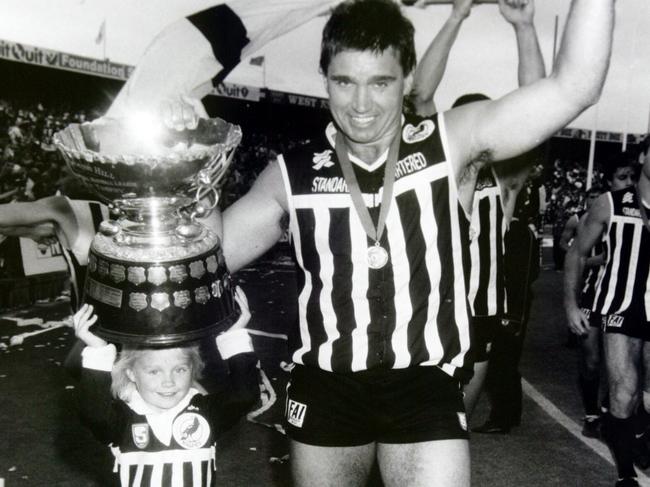 Greg Phillips and daughter Erin hold the SANFL premiership cup after Port Adelaide defeated Glenelg in the 1990 grand final.