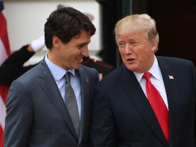 (FILES) US President Donald Trump (R) welcomes Canadian Prime Minister Justin Trudeau at the White House in Washington, DC, on October 11, 2017. The political circumstances that surrounded the publication of "Ultimatum," once a best-selling novel that imagined an American effort to annex Canada, may ring familiar to anyone following recent headlines. "Ultimatum," published in 1973, is authored by D-Day veteran Richard Rohmer, the honorary lieutenant general of the Canadian Armed Forces, who recently turned 101. Still an avid news consumer and writer, Rohmer told AFP that remarks by President-elect Donald Trump implying that Canada could be absorbed by the United States should not be laughed off. (Photo by JIM WATSON / AFP)