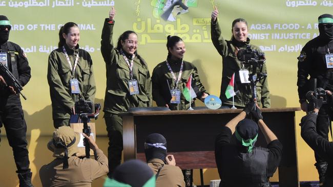 Israeli soldier hostages wave to a Palestinian crowd before being handed over to the Red Cross in Gaza City on Saturday. Picture: AP