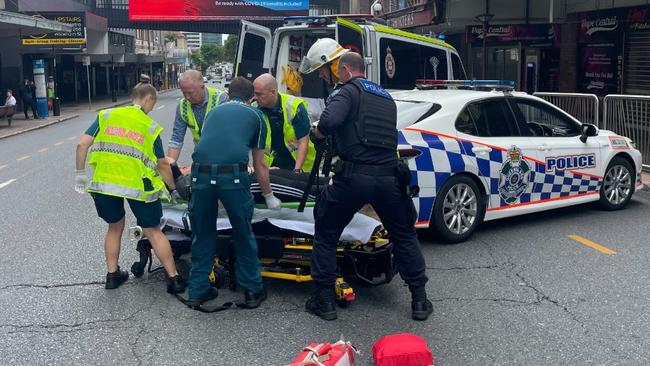 Police and ambulance crews attend to an injured e-scooter rider in Fortitude Valley.