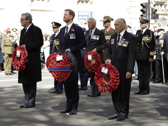 Prince Harry waits to lay a wreath flanked by Australian High Commissioner to Britain Alexander Downer, left, and New Zealand High Commissioner to Britain Jerry Mateparae during an Anzac Day service. Picture: AP Photo/Matt Dunham