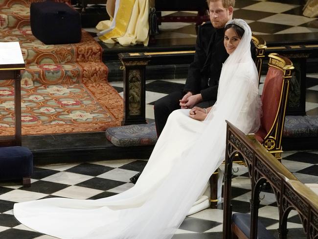 Britain's Prince Harry, Duke of Sussex (L) sits with US actor Meghan Markle (R) during the reading in St George's Chapel, Windsor Castle, in Windsor, on May 19, 2018 during their wedding ceremony. Picture: AFP PHOTO / POOL / Owen Humphreys