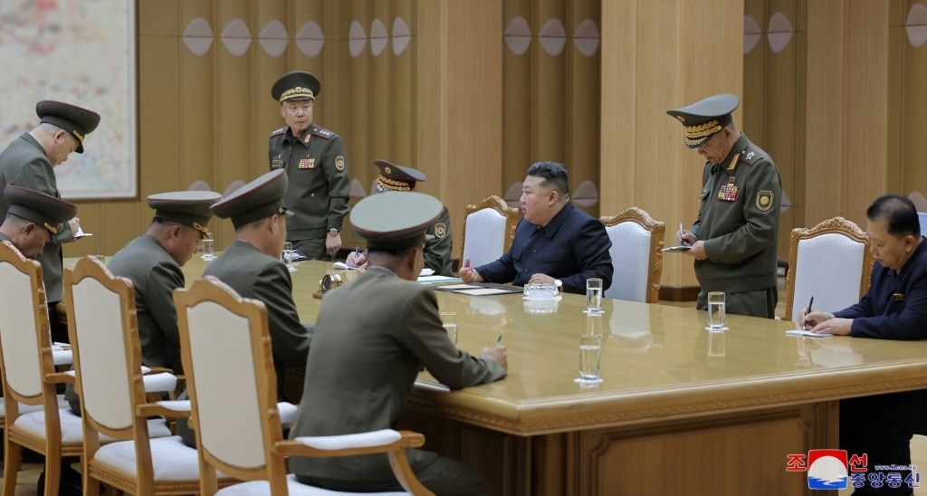 A picture released by North Korea's official Korean Central News Agency  via KNS shows Kim Jong Un (centre) at Monday's security meeting at an undisclosed location