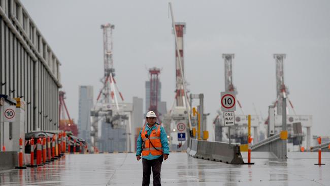 Security guards keep watch at the entrance to the West Gate Tunnel project site at Yarraville before this morning's employee lay-offs. Picture: Andrew Henshaw