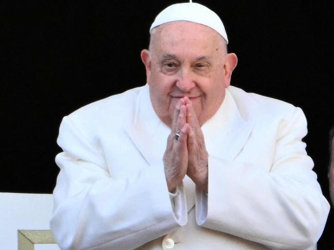 TOPSHOT - Pope Francis greets the crowd from the main balcony of St. Peter's basilica after the Urbi et Orbi message and blessing to the city and the world as part of Christmas celebrations, at St Peter's square in the Vatican on December 25, 2024. (Photo by Alberto PIZZOLI / AFP)