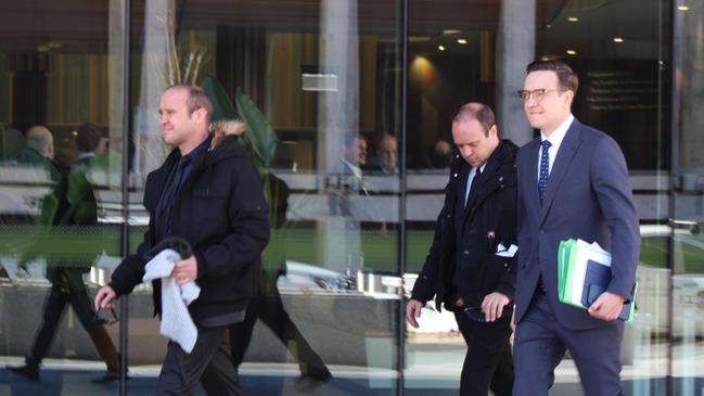 Australian Federal Police officer Joshua Rod Tiffen and his twin brother Kenan Lee Tiffen leave court with their lawyer, Tom Taylor.