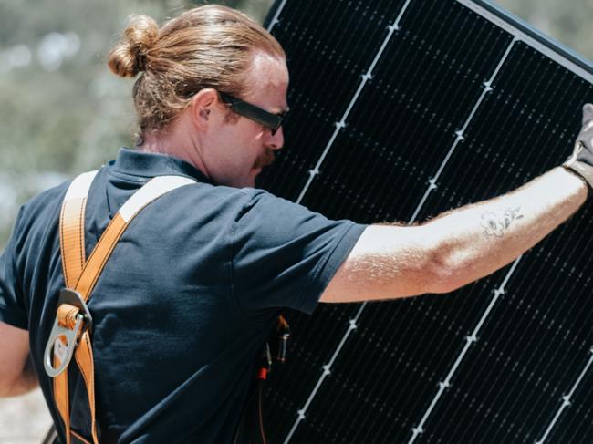 Smart Energy installer with a new solar panel. Picture: Supplied.