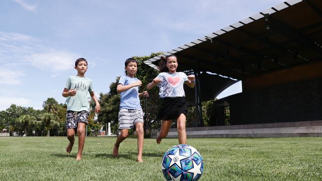 Ciaran Tamang, 7, Tara Tamang, 11, and Tashi Tamang, 9, of Brinsmead play a game of soccer in Munro Martin Parklands, which has been transformed into a stunning multi-purpose space which has hosted world-class outdoor concerts. Picture: Brendan Radke