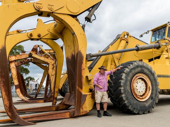 Journalist Charles Wooley with one of the log handling machines that has been preserved at the Triabunna Mill. Picture: ALASTAIR BETT