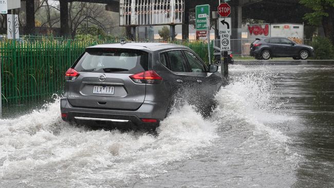 Water spills over Punt Rd as rain lashes Melbourne. Picture: David Crosling