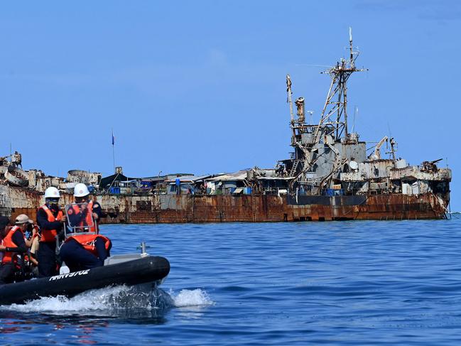 This photo taken on November 10, 2023 shows Philippine coast guard personnel and journalists sailing onboard a rigid inflatable boat (L) as they head back after filming the BRP Sierra Madre docked at Second Thomas Shoal in the disupted South China Sea. (Photo by JAM STA ROSA / AFP)