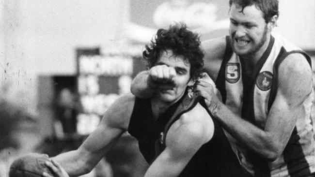 Footballer Mark Mickan – who was diagnosed with Parkinson’s 14 years after the end of his AFL and SANFL career – and Michael Parsons during a North Adelaide vs West Adelaide match at Prospect Oval in 1983. Picture: Peter Watkins