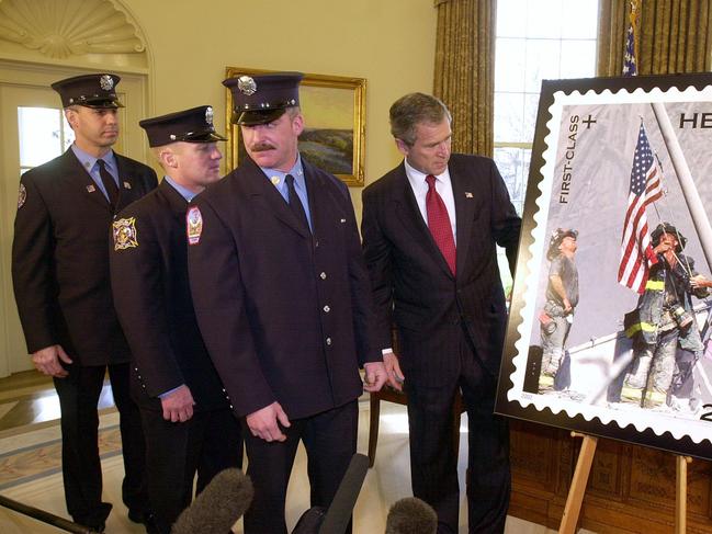 Former US President George W Bush (R) looks at the postage stamp depicting New York firefighter heroes of 9/11, with (L-R) Billy Eisengrein, George Johnson &amp; Dan McWilliam. Picture: Supplied