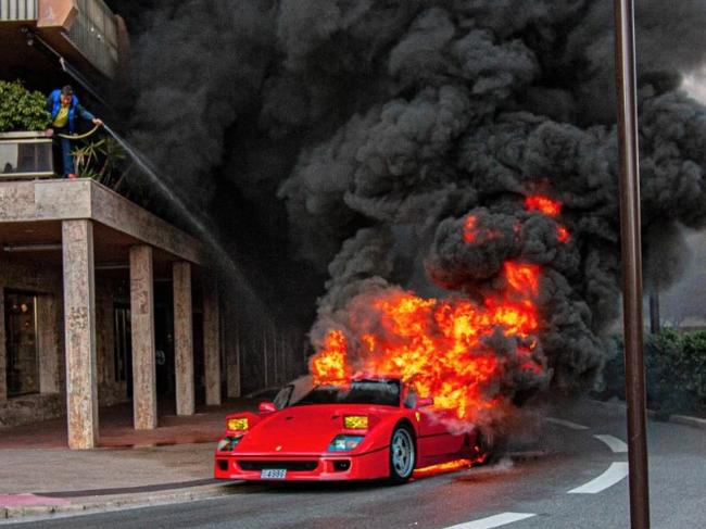 A man tried desperately to save the car by hosing it from his balcony. Picture: smih_carspotting/WENN/AAP