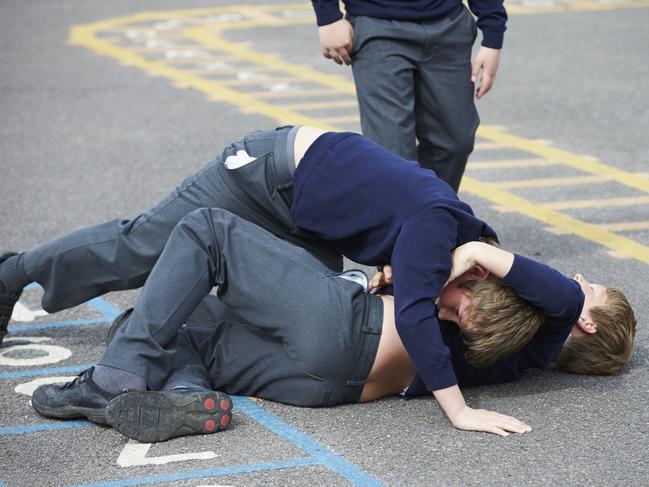 Two Boys Fighting In School Playground During Break Time