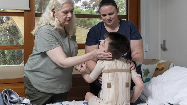 Ally and Janet Tanner help son Oscar, 6, with his orthotics. Picture: Monique Harmer