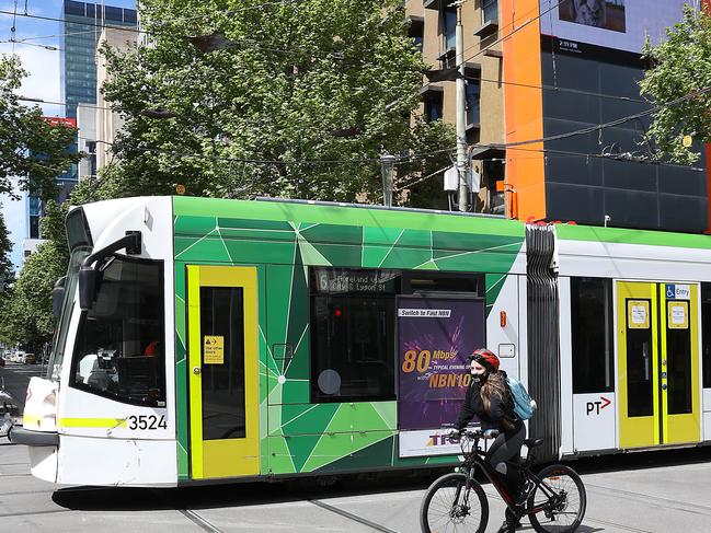 MELBOURNE, AUSTRALIA - NewsWire Photos OCTOBER 12, 2020 : Melbourne continues to battle a second wave of COVID-19. A cyclist and tram head north up Swanston Street.Picture : NCA NewsWire / Ian Currie