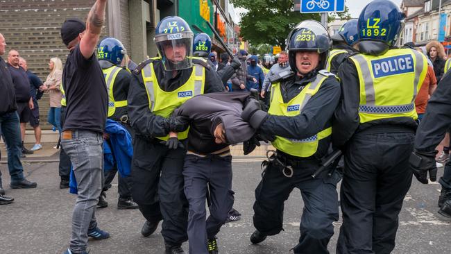 A man is detained in Middlesbrough, England. Almost 500 people have been arrested since the violence broke out. Picture: AFP