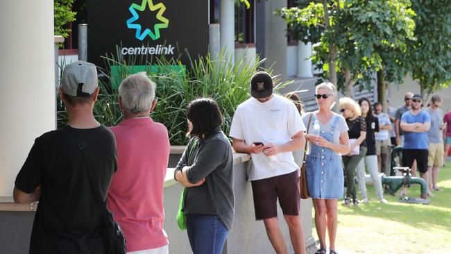 Hundreds of people queued outside Centrelink offices a day after pubs and restaurants were shut, hoping for support. Picture: Glenn Hampson