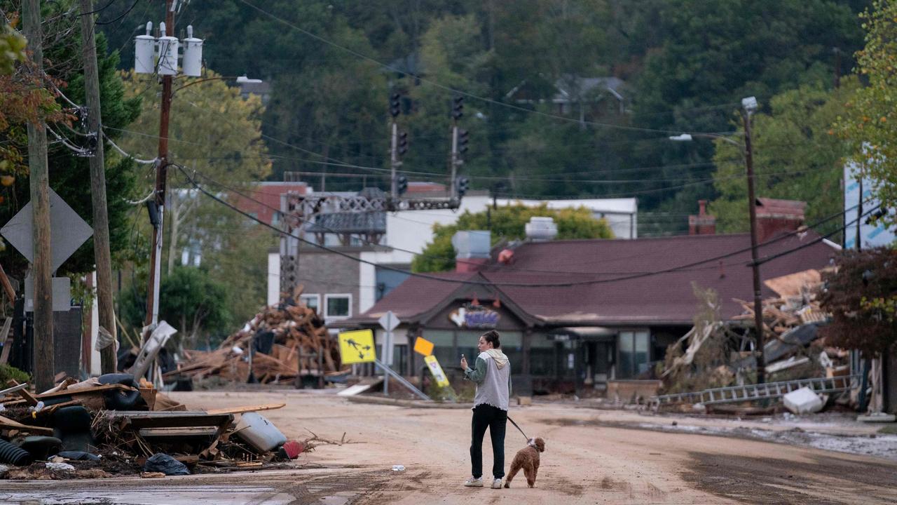 A woman called Mary Grace and her dog, Marley, walk around the Biltmore Village in the aftermath of Hurricane Helene in North Carolina. Picture: Getty Images via AFP