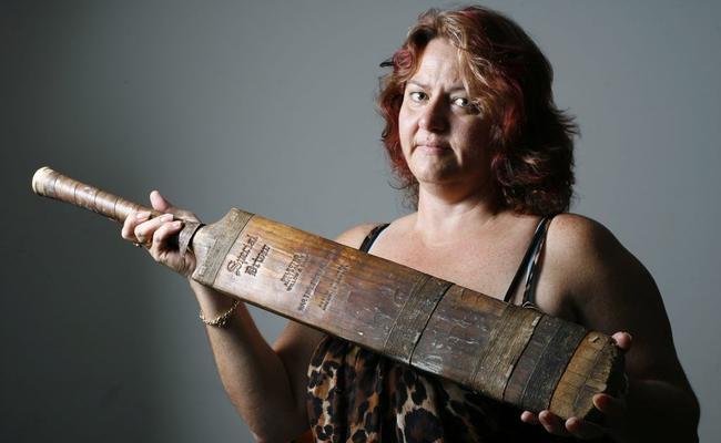 Sharon Wilson sits with a cricket bat found in the cubby house of a Burgess Street property in Raceview where she used to reside. Sharon is keen to find out the story behind the wartime cricket bat. . Picture: Claudia Baxter