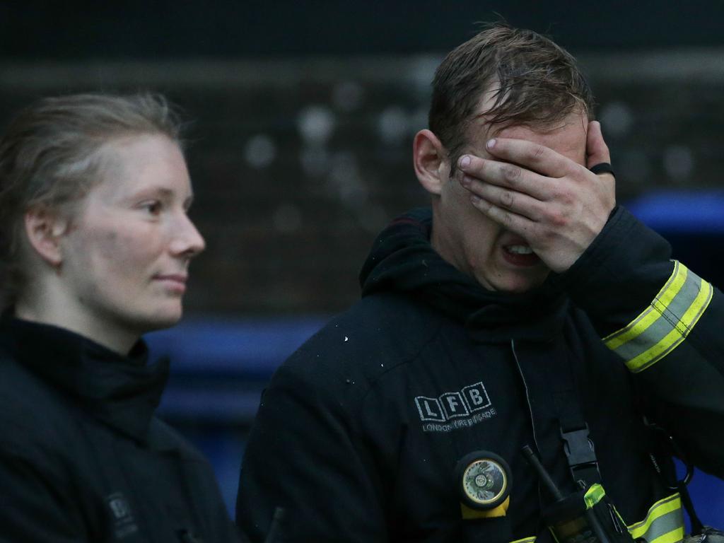 An emotional firefighter at the site of the huge fire engulfing the Grenfell Tower in west London early on June 14, 2017. Picture: AFP Photo/Daniel Leal-Olivas