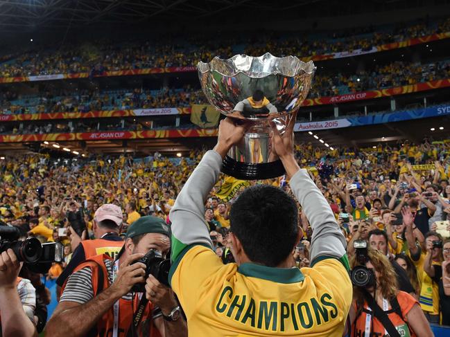 Australia's Tim Cahill lifts the AFC Asian Cup football trophy after beating South Korea at Stadium Australia in Sydney on January 31, 2015. AFP PHOTO / Saeed KHAN -- IMAGE RESTRICTED TO EDITORIAL USE - STRICTLY NO COMMERCIAL USE