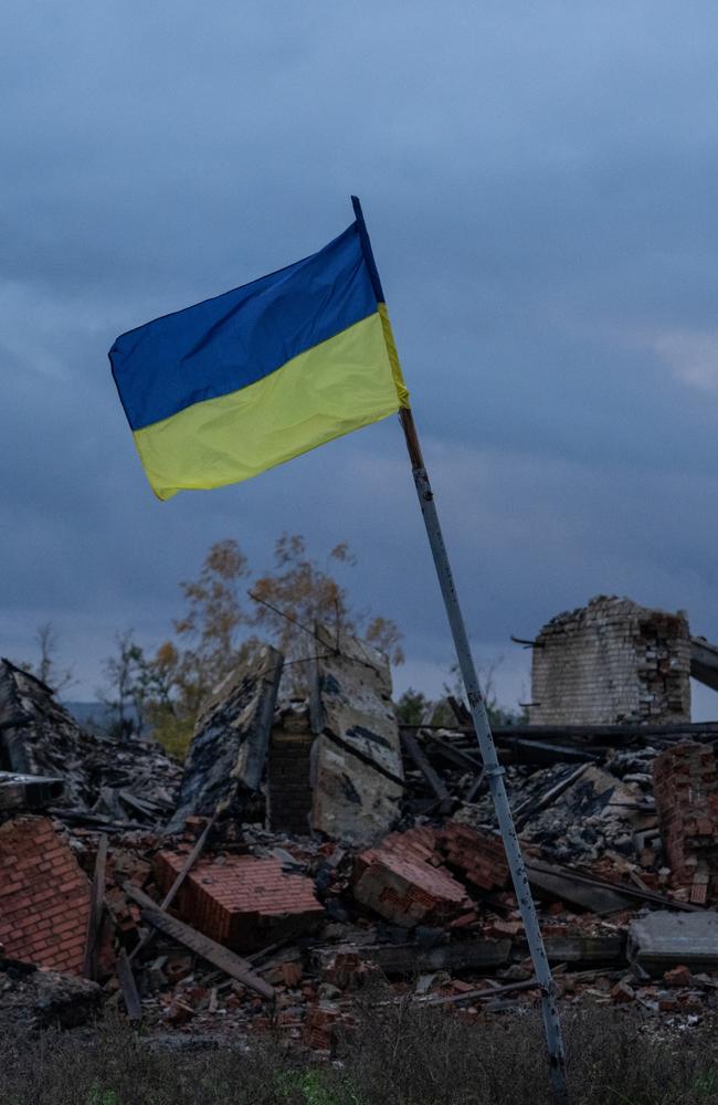 A Ukrainian flag flies above the ruins of a building. Photo by Carl Court/Getty Images