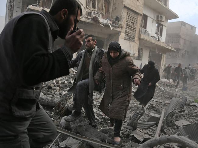 Civilians flee from an area hit by a regime air strike in the rebel-held town of Saqba. Picture: Abdulmonam Eassa/AFP