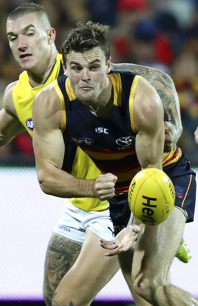 Adelaide Crows’ Brad Crouch gets his handpass away past Richmond’s Dustin Martin.