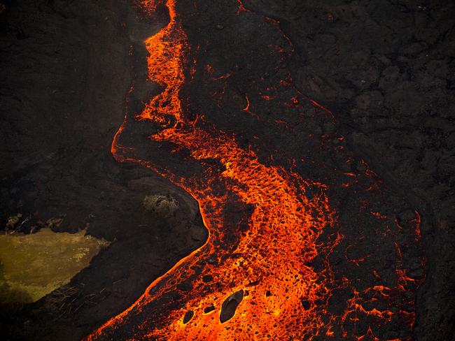 Lava from the Kilauea volcano erupts from a fissure and forms a river flowing down to Kapoho in Pahoa, Hawaii. Picture: AP Photo/L.E. Baskow