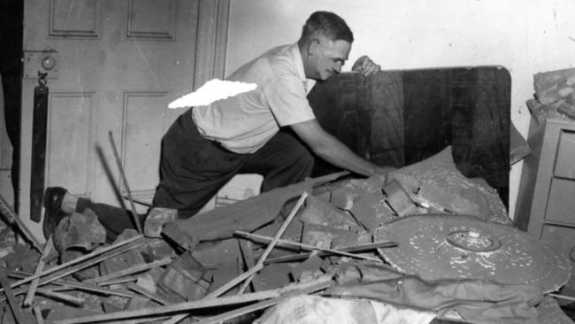 An Adelaide man cleans up his house following the 1954 earthquake