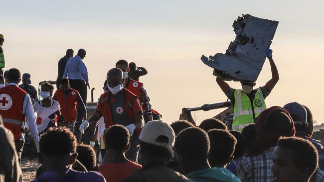 A man carries a piece of debris of the stricken plane at crash site. Picture: AP