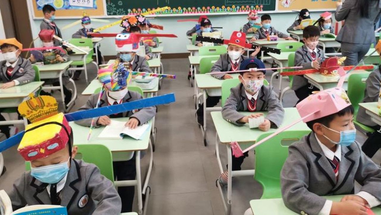Students at Yangzheng Primary School Hangzhou, China return to school with wide hats to ensure they stay apart. Picture: Zhejiang Daily via @SixthTone/Twitter