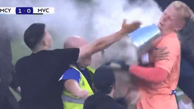 Tom Glover is hit by a bucket as fans storm the pitch.