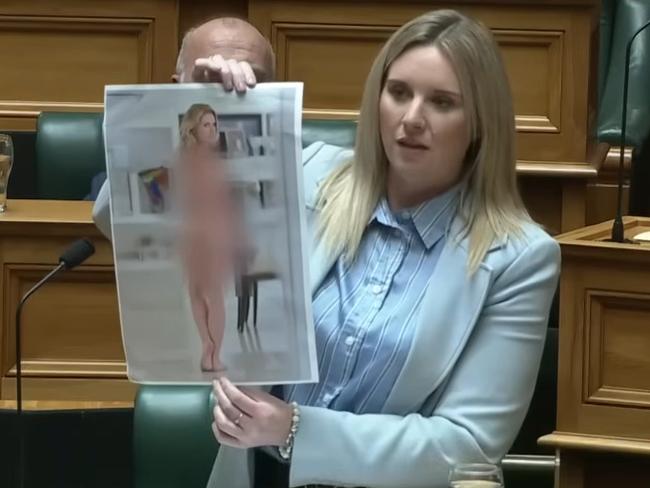 Laura McClure holds up doctored nude image of herself. Picture: YouTube / ACT New Zealand