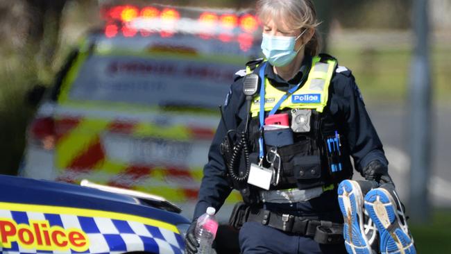 An officer holds a pair of shoes as police gather evidence from the crime scene. Picture: NCA NewsWire/Andrew Henshaw