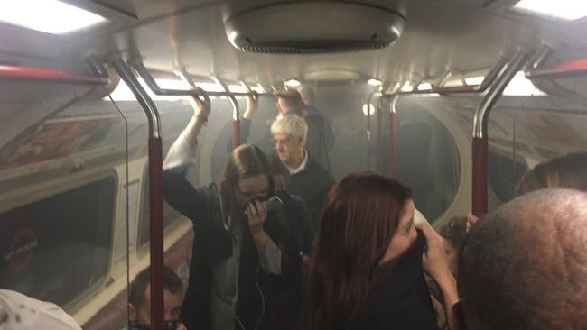 In this photo provided by Joe Bunting, commuters cover their mouths as smoke fills the carriage of a Bakerloo line train, near Oxford Circus in London. Picture:  Joe Bunting/AP