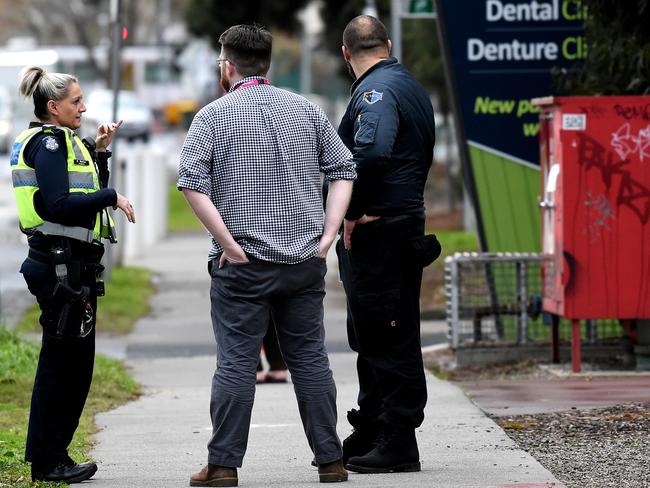 Police speak to security and a North Richmond Community Health staff member after a woman was assaulted. Picture: Nicole Garmston