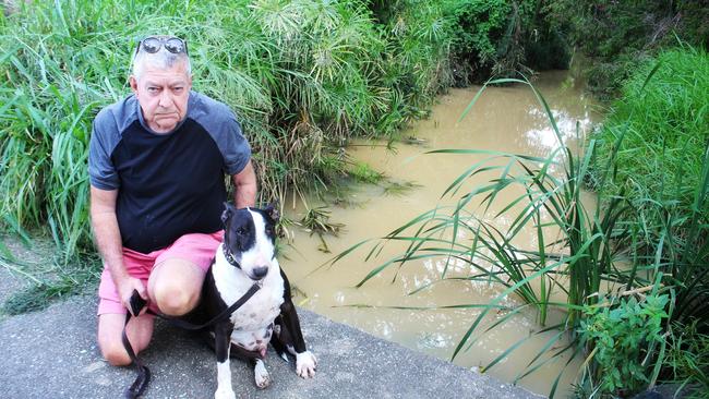 Bob Barclay, pictured with his dog Biggles, at a polluted section of sandy Creek, about 50m east of Old Northern Rd, where the water turned opaque. Photo: Glenn Roberts