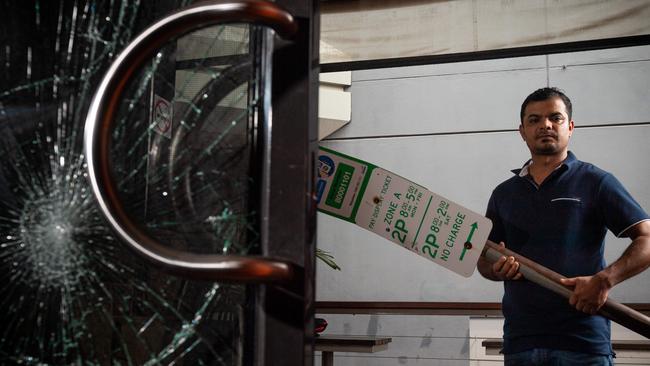 Outback Steaks & Curry has been hit again by thieves, the second break-in in a matter of days. Co-owner Deepak Sharma stands with the street sign the perpetrators used to smash the windows. Picture: Che Chorley