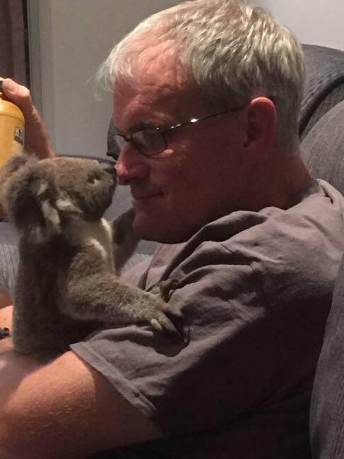 Peter Luker, 55, with a koala joey rescued following a bushfire in Queensland in December. Picture: Peter Luker