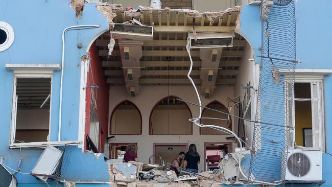 A Lebanese couple inspect the damage to their house in an area overlooking the destroyed Beirut port. Picture: Joseph Eid/AFP