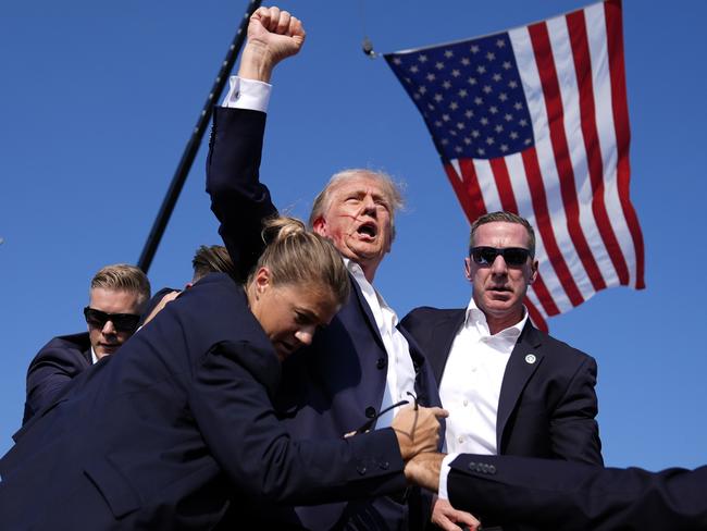 Republican presidential candidate Donald Trump is surrounded by U.S. Secret Service agents after shots were fired at a Pennsylvania campaign rally. Picture: AP Photo/Evan Vucci