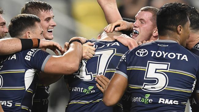 Teammates gather around Heilum Luki after he scored his first ever try for the Cowboys. Picture: Getty Images