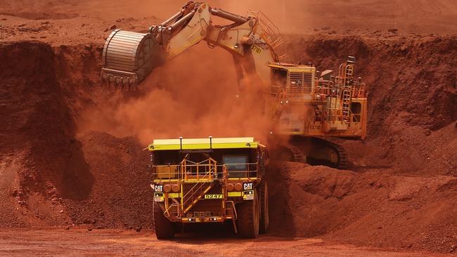 An excavator loads ore into an autonomous dump truck at Fortescue Metals Group Ltd.'s Solomon Hub mining operations in the Pilbara region, Australia, on Thursday, Oct. 27, 2016. Shares in Fortescue, the world's No. 4 iron ore exporter, have almost trebled in 2016 as iron ore recovered, and the company cut costs and repaid debt. Photographer: Brendon Thorne/Bloomberg via Getty Images