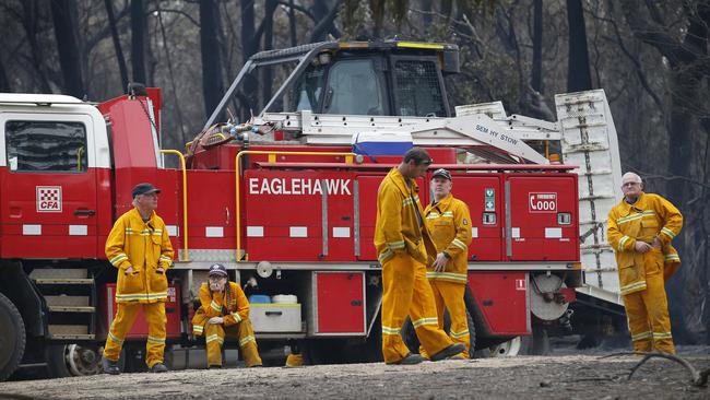 Tired CFA firefighters rest while they refuel during the Mallacoota fire fight. Picture: David Caird